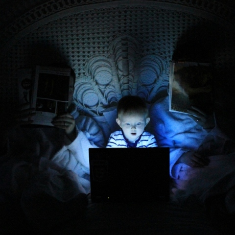 παιδι μπροστα σε laptop μαζί με 2 γονείς