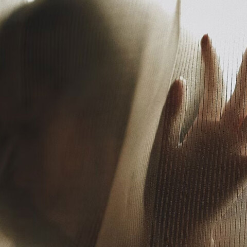 Γυναίκα με υψωμένα χέρια πίσω από κουρτίνα - Εικόνα που παραπέμπει σε βιασμό