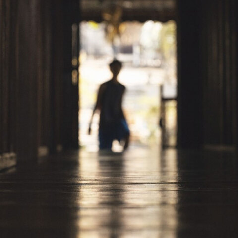 Νεαρό αγόρι στο βάθος διαδρόμου - Φωτογραφία που παραπέμπει σε μυστήριο και κακοποίηση