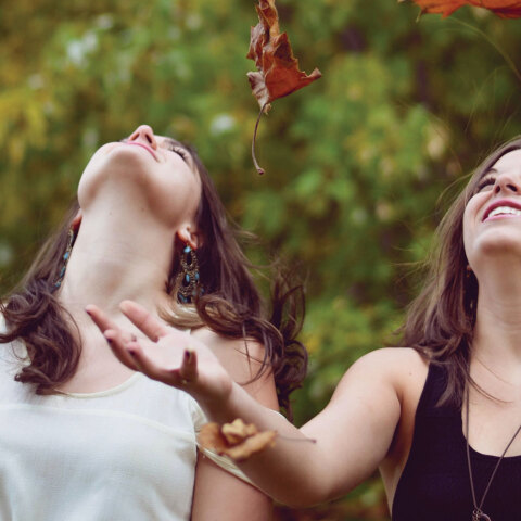 Κορίτσια παίζουν με πεσμένα φύλλα