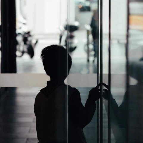 Παιδί σε σκοτεινό διάδρομο - Εικόνα που παραπέμπει σε κακοποίηση παιδιού