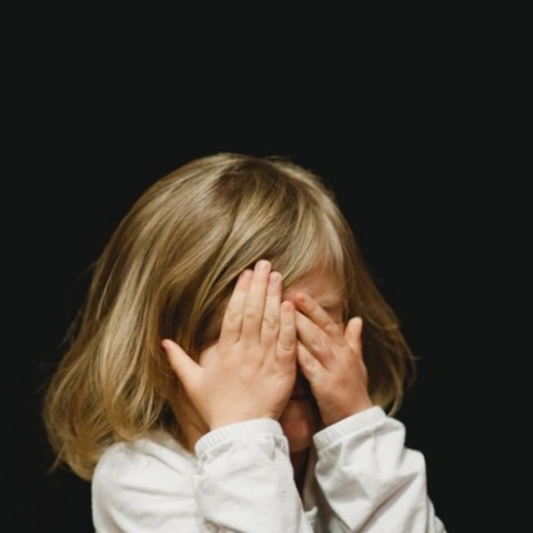 Παιδί κρύβει το πρόσωπό του - Εικόνα που παραπέμπει σε κακοποίηση
