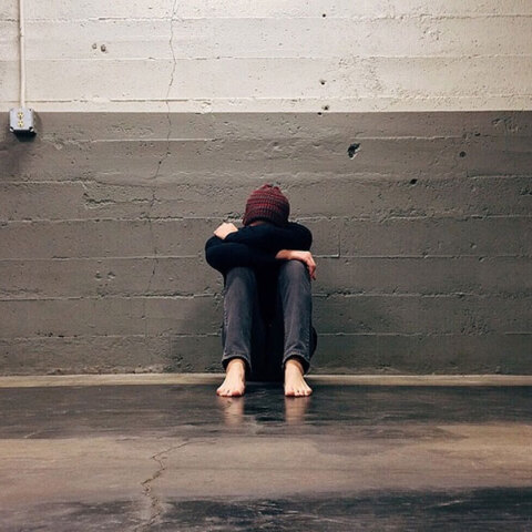 Παιδί με τα χέρια στα πόδια του κάθεται σε διάδρομο 