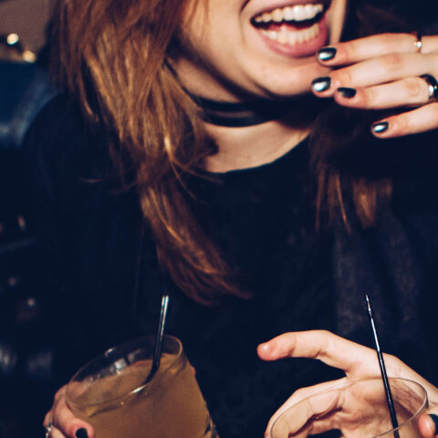 Άνθρωποι γελάνε και κρατάνε ποτά