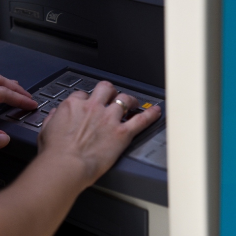 Χέρι με βέρα πληκτρολογεί σε ΑΤΜ