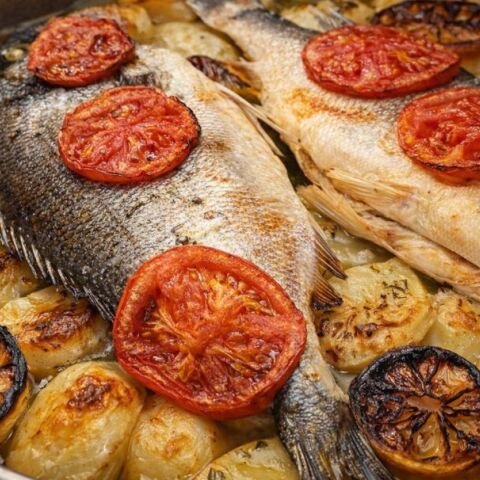 Τσιπούρα στον φούρνο με πατάτες, κρεμμύδια, λεμόνια και ντομάτα