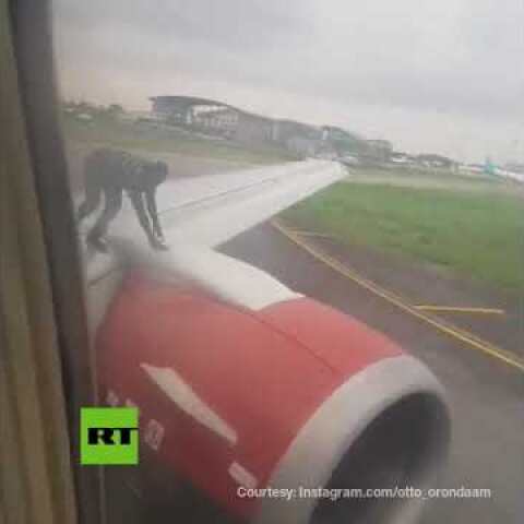 Man climbs on plane wing as it prepares for takeoff