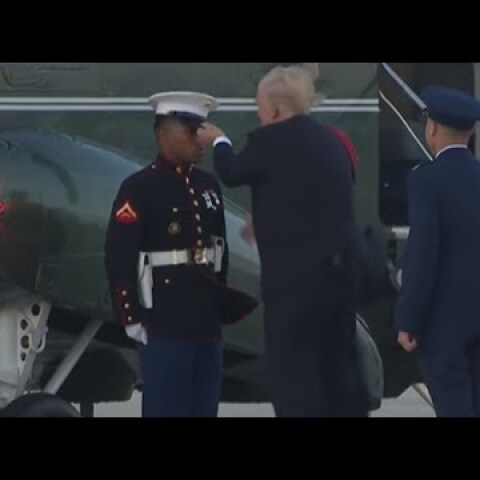 Trump struggles to retrieve marine hat blown off by the wind