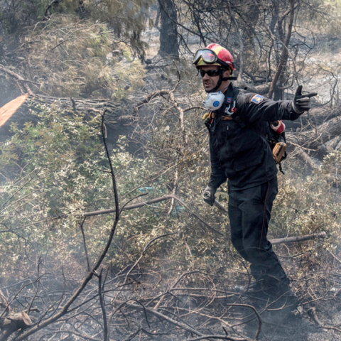Πυροσβέστης επιχειρεί στην κατάσβεση της πυρκαγιά κοντά στο χωριό Μακρυμάλλη