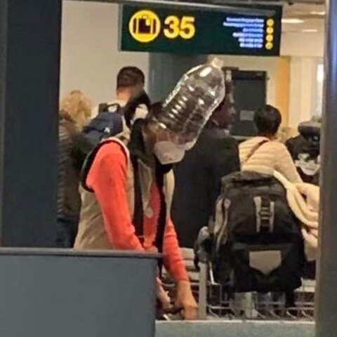 Κοροναϊός: Κινέζα τουρίστρια με προστατευτική μάσκα και πλαστικό μπουκάλι στο κεφάλι