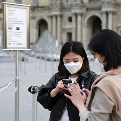 Κοπέλες με προστατευτικές μάσκες και κινητά