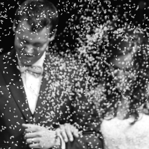 Ασπρόμαυρη φωτογραφία με ζευγάρι που παντρεύται και του πετάνε ρύζι