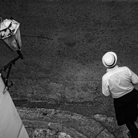 Φωτογραφία με έναν άνθρωπο με καπέλο στον άδειο δρόμο του Συντάγματος