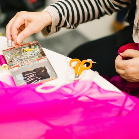 Γυναίκα πιάνει καρφίτσες από το τραπέζι