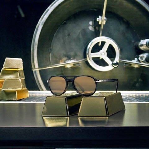 Γυαλιά ηλίου Persol ακουμπισμένα πάνω σε πλάκες χρυσού