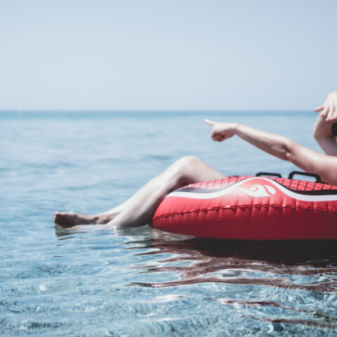 Γυναίκα κάθεται σε φουσκωτή κουλούρα στην θάλασσα