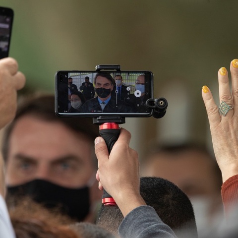 Ο Μπολσονάρου με μάσκα μέσα από την οθόνη ενός κινητού