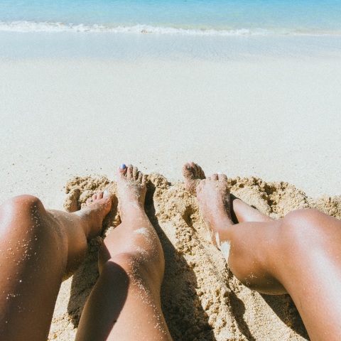 Γυναικεία πόδια στην άμμο παραλίας
