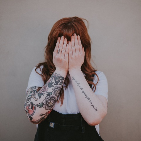 Γυναίκα που κρύβει με τα χέρια της το πρόσωπό της