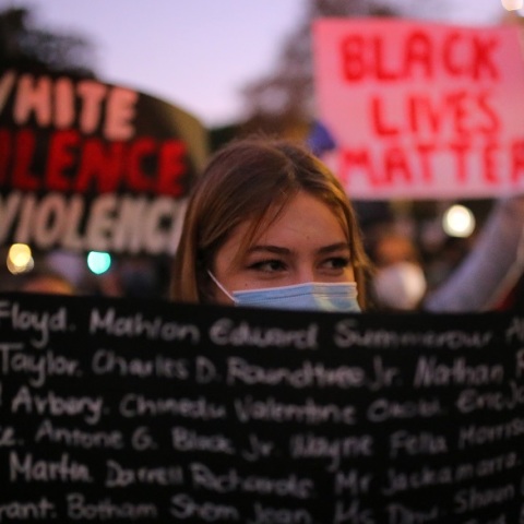 Μία κοπέλα κρατάει ένα πανό 