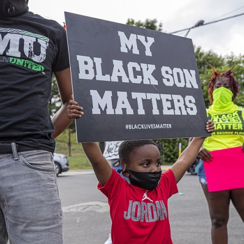Ένα μικρό παιδί στις ΗΠΑ κρατάει πανό κατά του ρατσισμού