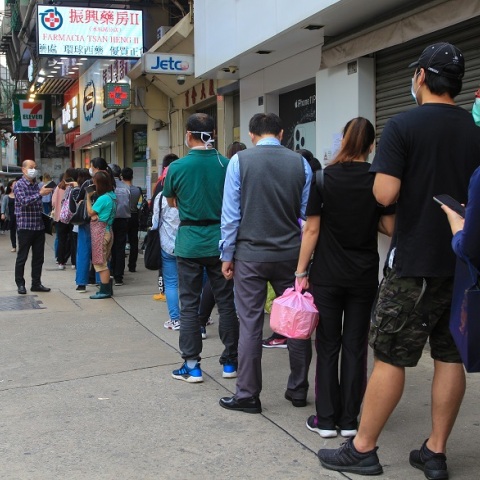 Άνθρωποι περιμένουν στην ουρά φορώντας μάσκες