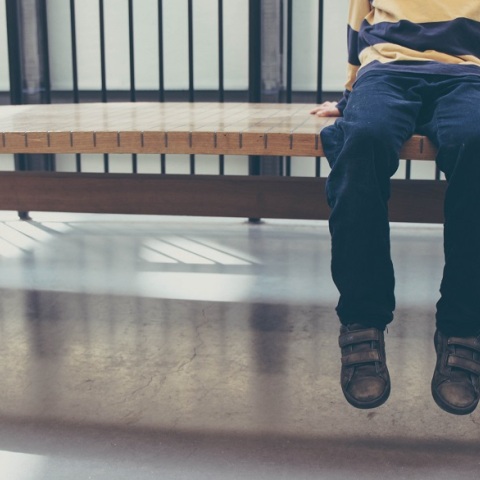 Παιδί κάθεται σε παγκάκι