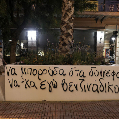 Συνθήματα στις ζαρντινιέρες με τους φοίνικες στην οδό Πανεπιστημίου κατά μήκος του «Μεγάλου Περιπάτου της Αθήνας»