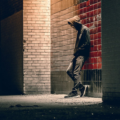 Άνδρας με κουκούλα στο σκοτάδι