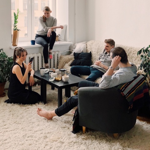 Αγόρια και κορίτσια αράζουν στο σαλόνι ενός σπιτιού