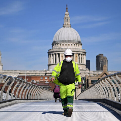 Μεγάλη Βρετανία: Εργάτης με μάσκα για τον κορωνοϊό διασχίζει τη Millennium Bridge στο Λονδίνο