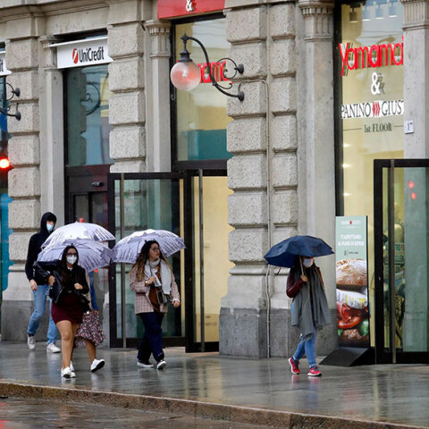 Κορωνοϊός στην Ιταλία: Κάτοικοι στο Μιλάνο περπατούν με προστατευτική μάσκα σε πεζοδρόμιο της πόλης