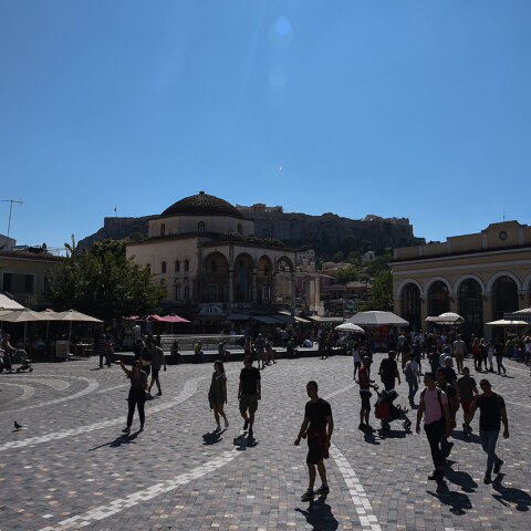 Κόσμος περπατά στην πλατεία στο Μοναστηράκι, με κάποιους να φορούν μάσκα για τον κορωνοϊό