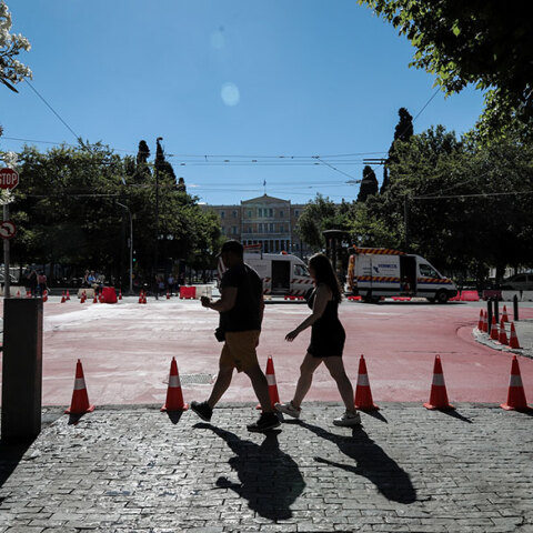 Περαστικοί περνούν από την πλατεία Συντάγματος