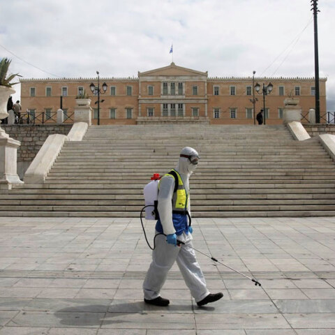 Υπάλληλος του Δήμου Αθηναίων στην πλατεία Συντάγματος με εξοπλισμό απολύμανσης για τον κορωνοϊό