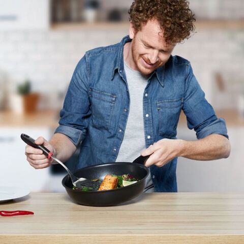 Άνδρας σε κουζίνα κρατάει τηγάνι από τη σειρά Tefal Unlimited