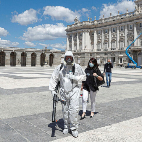 Κορωνοϊός στην Ισπανία: Υπάλληλος με προστατευτική μάσκα για τον κορωνοϊό απολυμαίνει ανοικτό χώρο