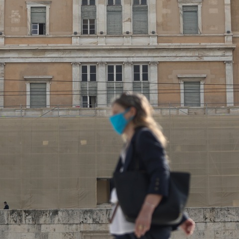 Γυναίκα που φορά χειρουργική μάσκα έξω από την Βουλή