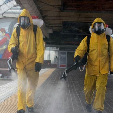 Άνδρες με προστατευτικές στολές για τον κορωνοϊό στη Μόσχα