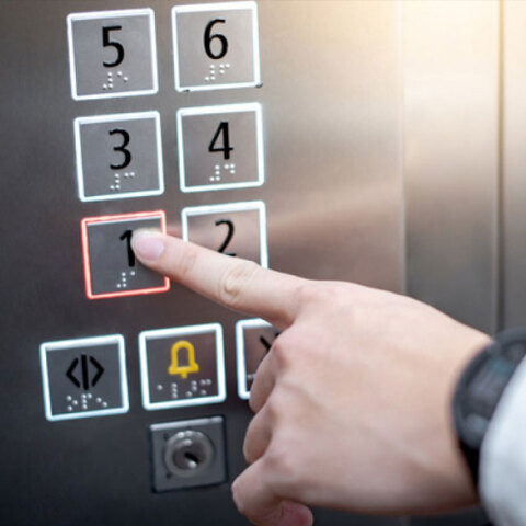 Άνδρας πατά το κουμπί σε ανελκυστήρα