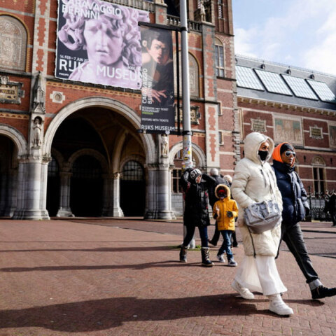 Πολίτες με μάσκα για τον κορωνοϊό περπατούν στο Άμστερνταμ