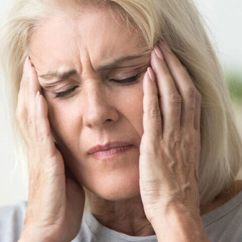 Ηλικιωμένη γυναίκα πιάνει το κεφάλι της με τα χέρια