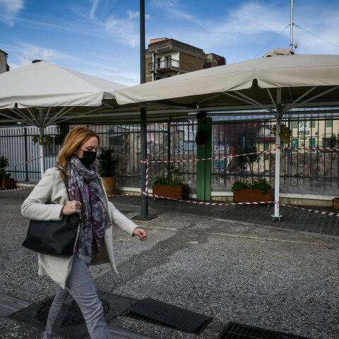 Γυναίκα με μάσκα για τον κορωνοϊό διασχίζει πεζόδρομο στο κέντρο της Αθήνας εν μέσω lockdown