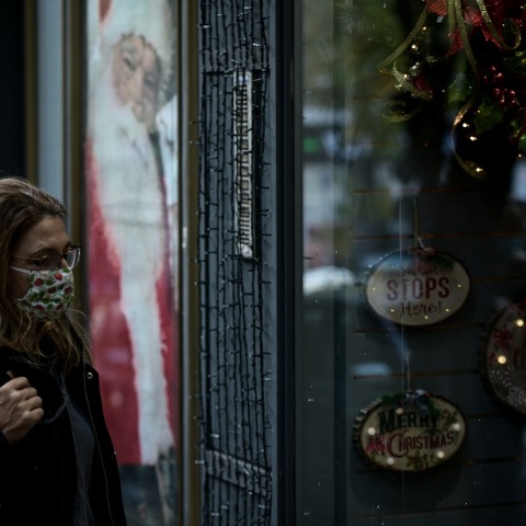 Γυναίκα με μάσκα στη χριστουγεννιάτικη αγορά 