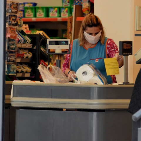 Εργαζόμενη με προστατευτική μάσκα για τον κορωνοϊό σε σούπερ μάρκετ