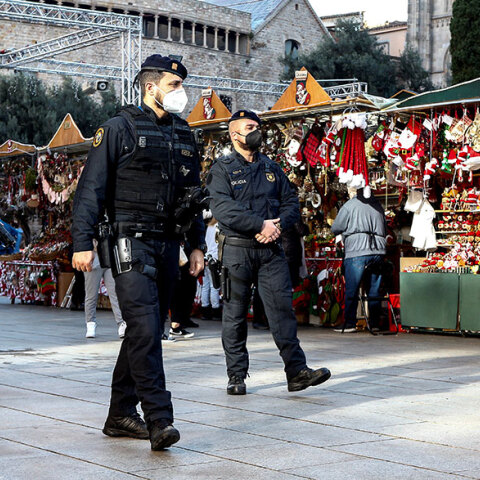 Αστυνομικοί με μάσκα για τον κορωνοϊό περιπολούν σε υπαίθρια αγορά με χριστουγεννιάτικα είδη στη Βαρκελώνη