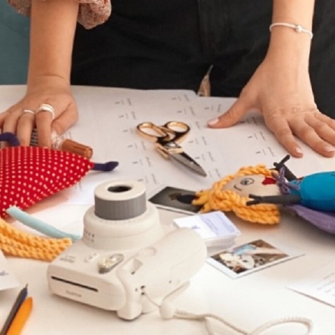 Τραπέζι με κινητό, φωτογραφική μηχανή, κουκλάκια