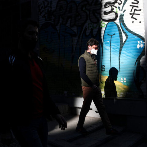 Κάτοικος στην Κωνσταντινούπολη με μάσκα για τον κορωνοϊό περνά μπροστά από κλειστό κατάστημα