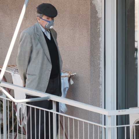Ηλικιωμένος που φοράει μάσκα στο μπαλκόνι του