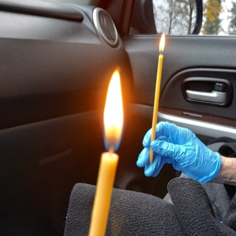 Χέρια που κρατούν αναμμένα κεριά μέσα σε αυτοκίνητο